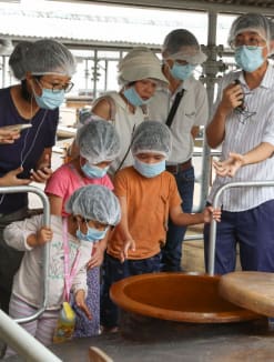 A guide explaining the soy sauce production process to participants at the Tai Hua soy sauce factory on July 26, 2024. 